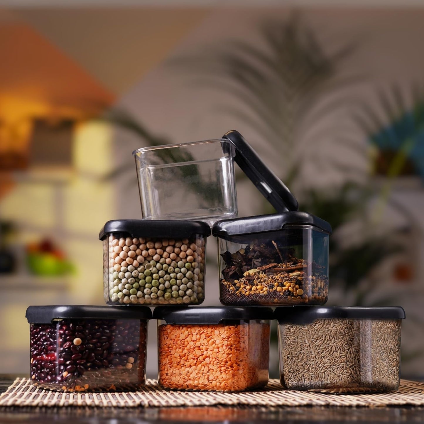 Airtight container with clip-lock lid open, showing chickpeas, whole spices, kidney beans, red lentils and cumin seeds stored inside