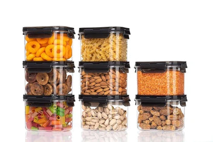 Airtight plastic storage containers with black clip-lock lids, filled with an assortment of pantry staples including pasta, dried fruits, nuts and lentils